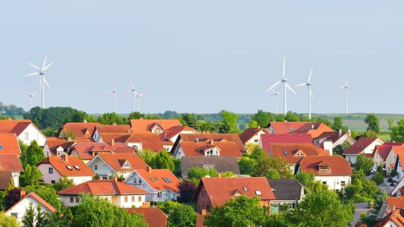 Windenergieanlagen in der Nähe einiger Häuser.