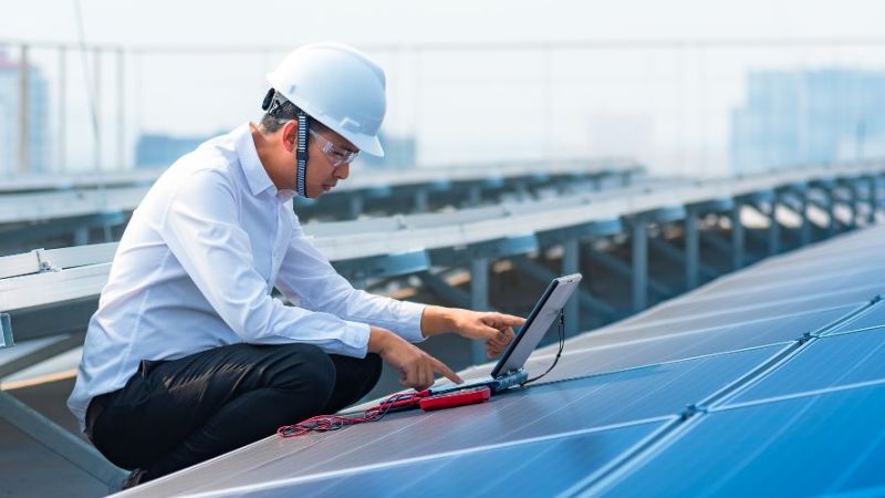 Symbol photo: Engineer checks the operation of a solar system.