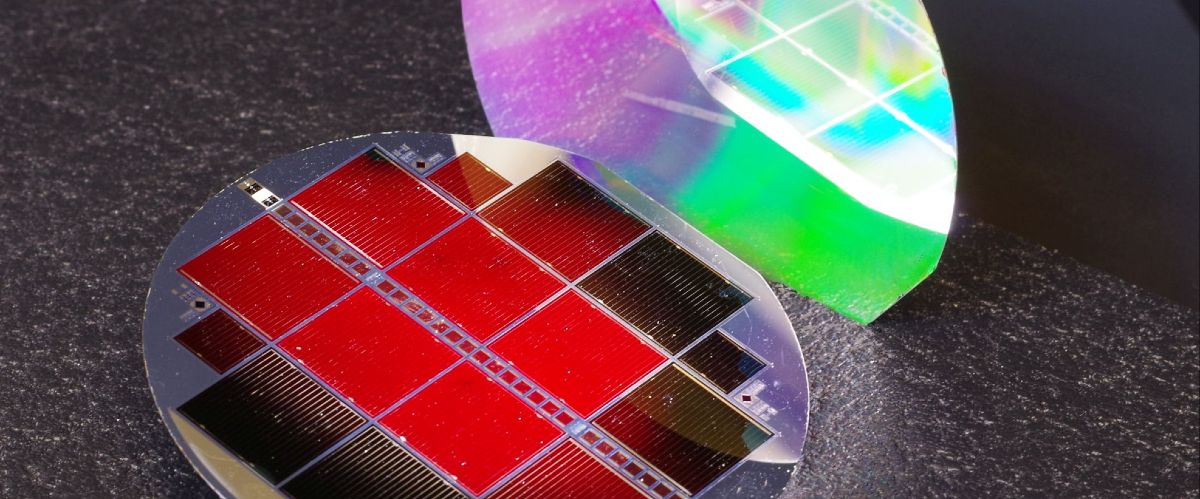 The new III-V//silicon tandem solar cell with 35.9 % efficiency. The top subcell glows red, a sign of excellent material quality. The nano-structured rear side shimmers in rainbow colours.