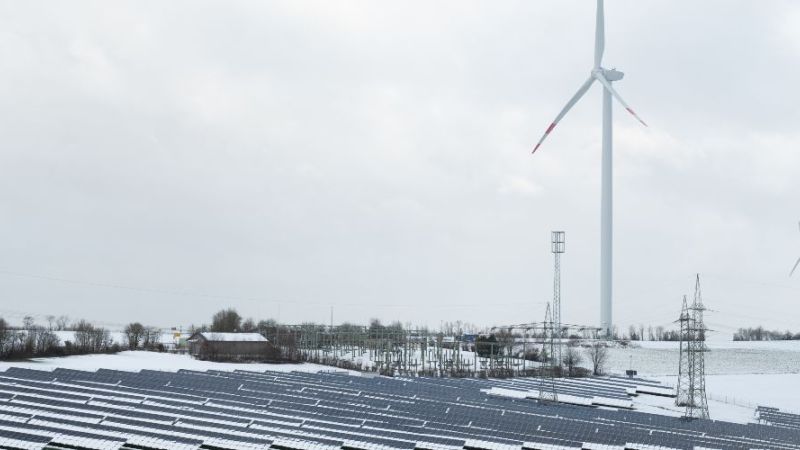 Snowy landscape with wind turbines and photovoltaic systems